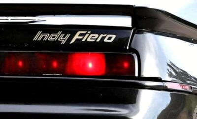 Close-up of the rear light and spoiler of a black Indy Fiero car.