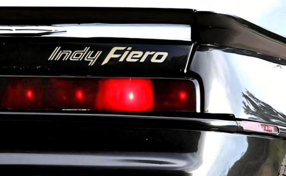 Close-up of the rear light and spoiler of a black Indy Fiero car.