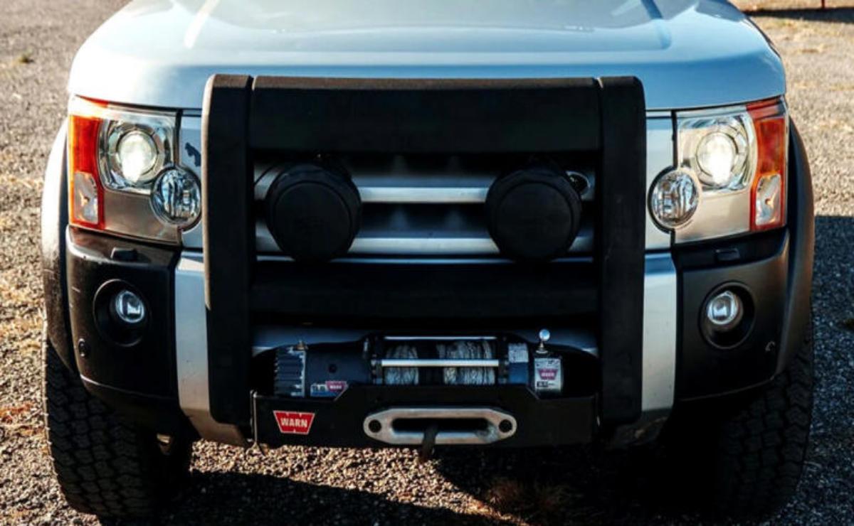 Front view of a rugged vehicle with a heavy-duty winch and protective grille.