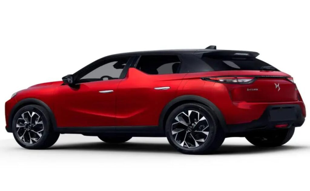 A man working on his laptop and writing in a notebook at a desk.