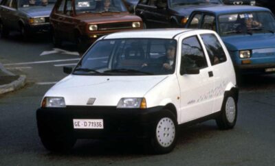 A white compact hatchback car parked on a street.