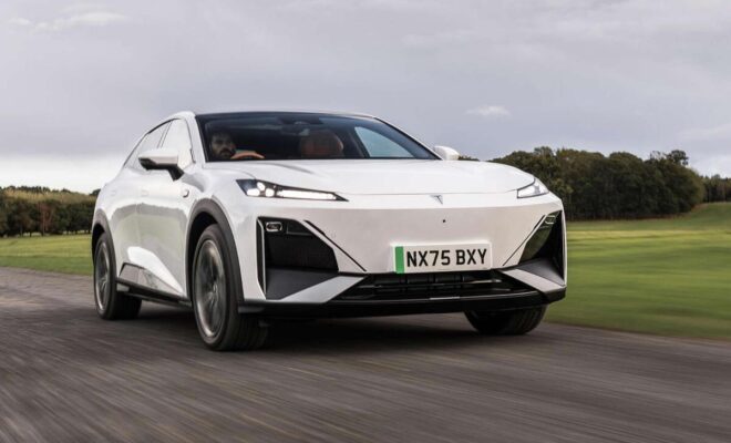 Sleek white electric SUV driving on a rural road.