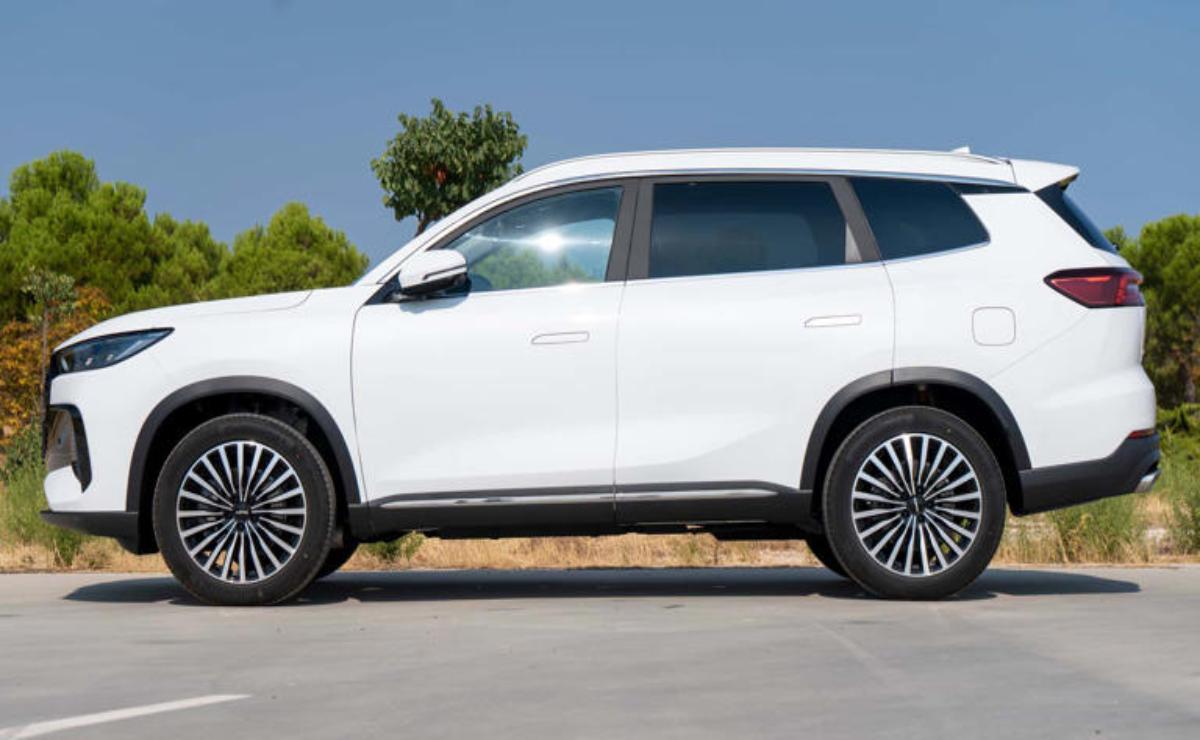 White luxury SUV parked outdoors with clear sky.