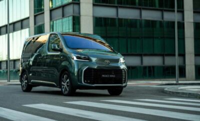 A sleek black Toyota Aygo X parked on a city street near a crosswalk.
