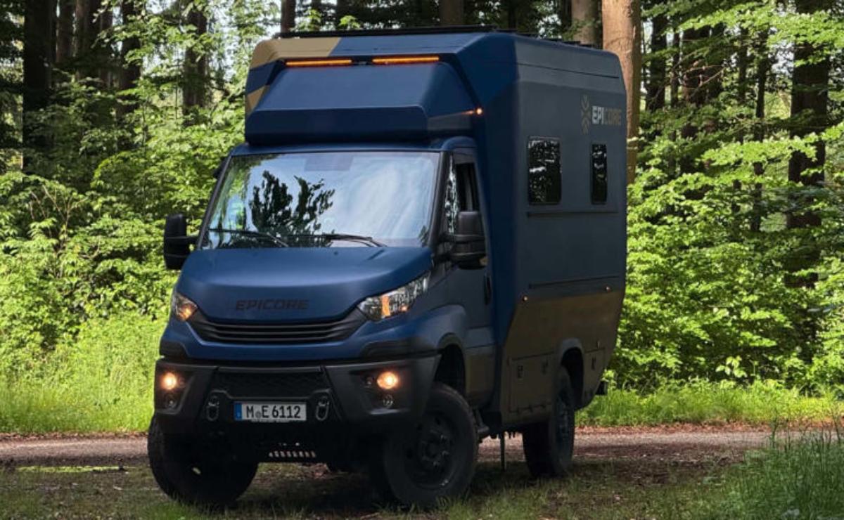 A rugged off-road camper van parked in a forest clearing.