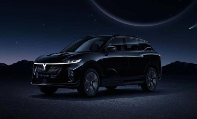 A sleek black electric SUV under a dark, futuristic sky.