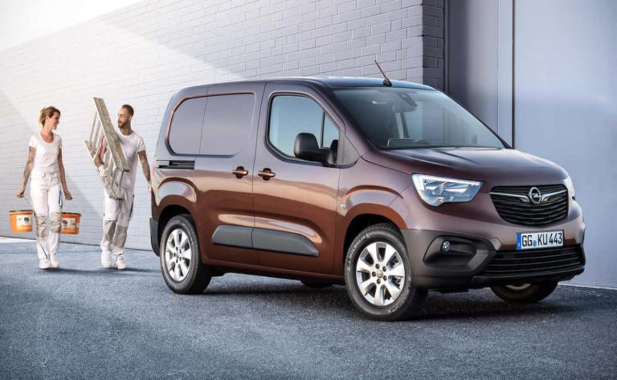 A brown modern cargo van parked near a building with a woman standing beside it.