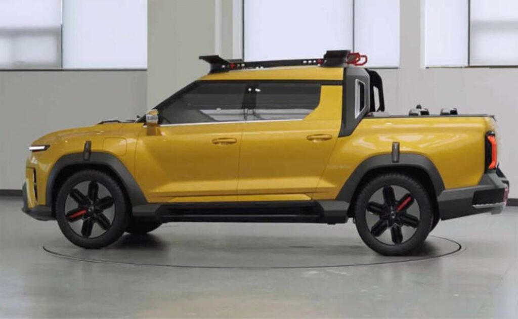 A man working on his laptop and writing in a notebook at a desk.