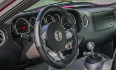 Close-up of a car's steering wheel and dashboard with detailed gauges.