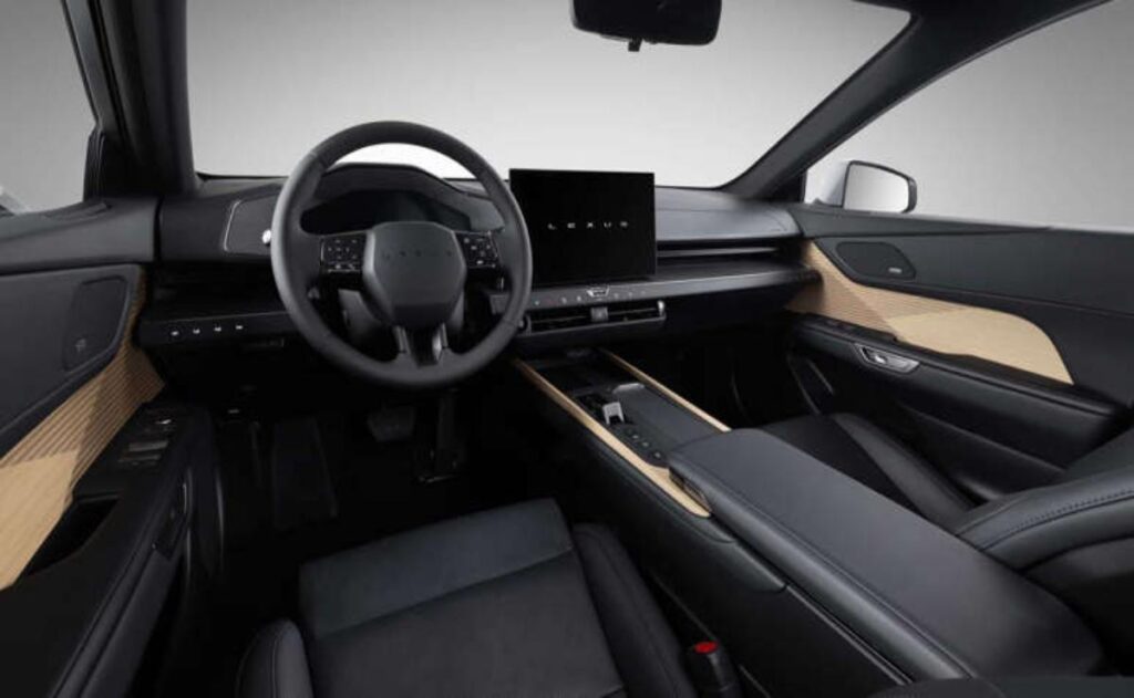 A man working on his laptop and writing in a notebook at a desk.