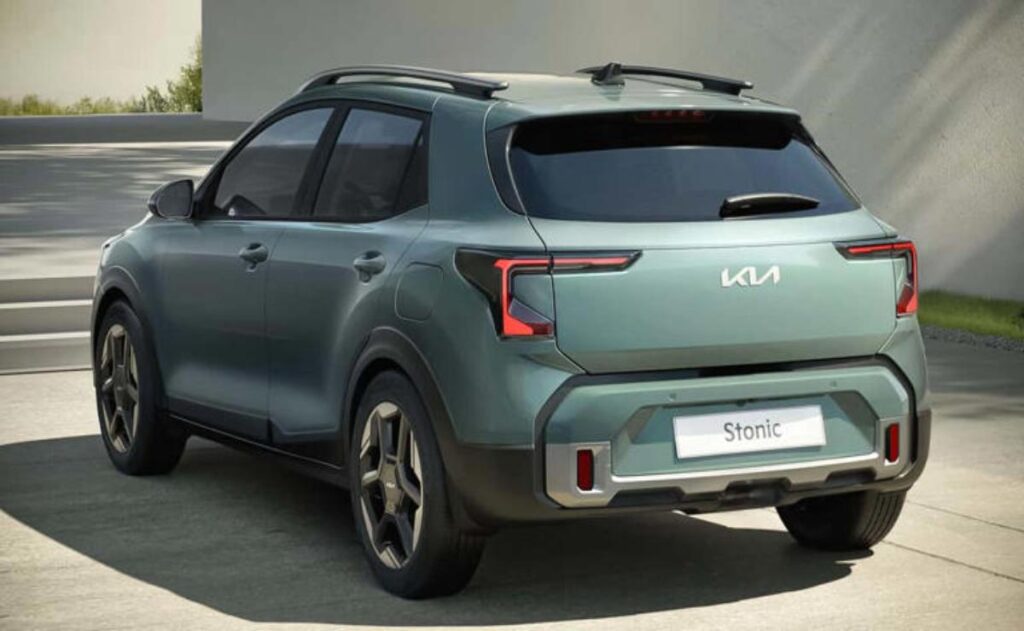 A man working on his laptop and writing in a notebook at a desk.
