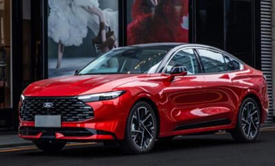 A sleek red sports sedan parked indoors with modern design features.