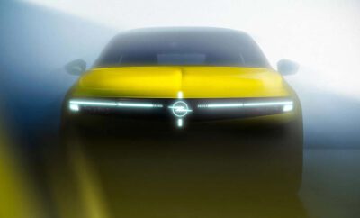 Futuristic yellow car with sleek LED headlights and a glowing emblem.