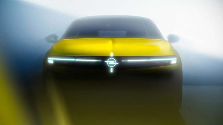 Futuristic yellow car with sleek LED headlights and a glowing emblem.