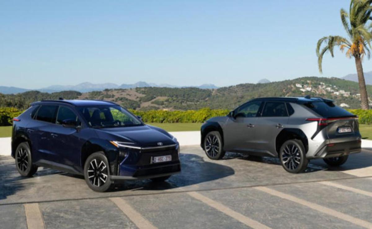 Two modern SUVs parked side by side in an open area with hills in the background.