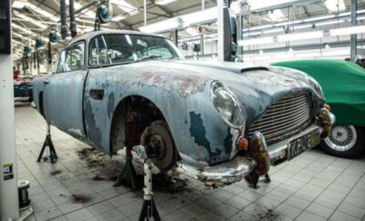Rusty vintage car without wheels in a garage.
