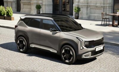 A sleek silver SUV parked on a city street with classic architecture.