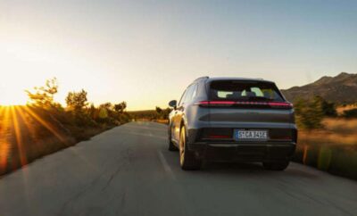 A car driving on a rural road during sunset.