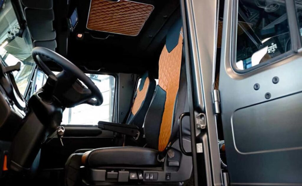 A man working on his laptop and writing in a notebook at a desk.