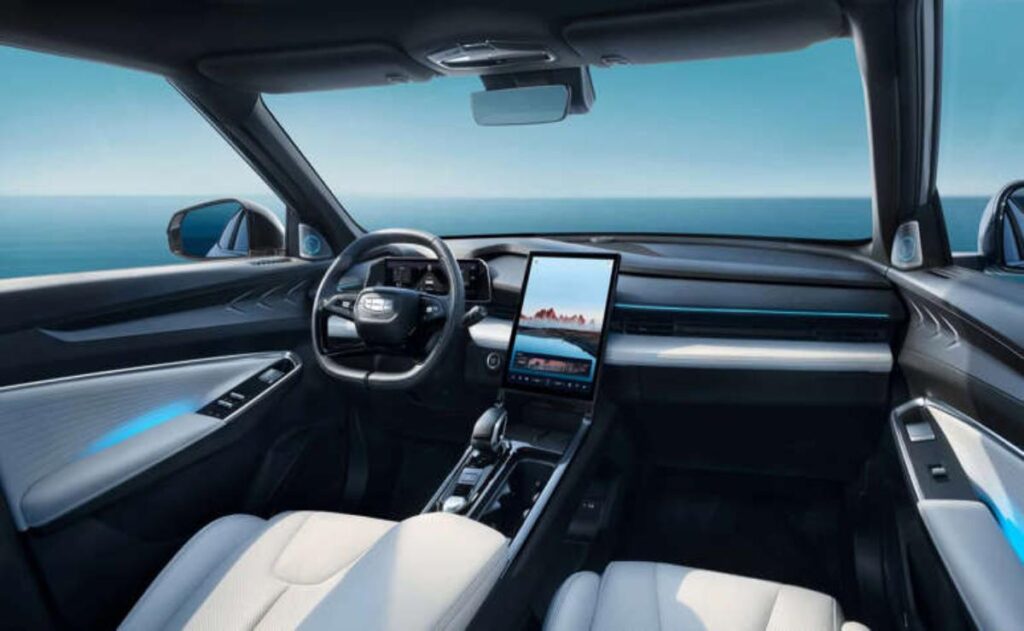 A man working on his laptop and writing in a notebook at a desk.