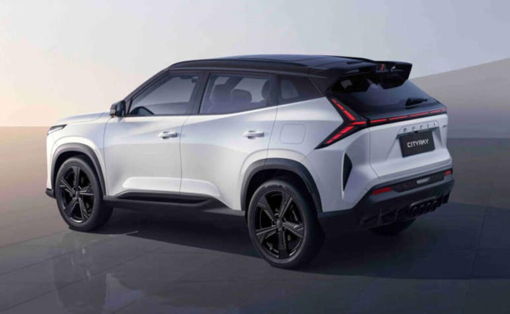 A man working on his laptop and writing in a notebook at a desk.