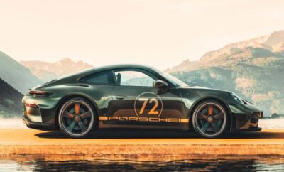 A sleek black Porsche 911 Carrera with racing decals on a scenic road.