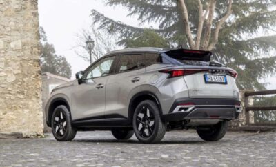 Silver SUV parked on a paved street under trees.
