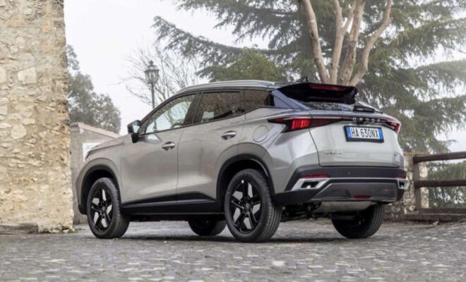 Silver SUV parked on a paved street under trees.
