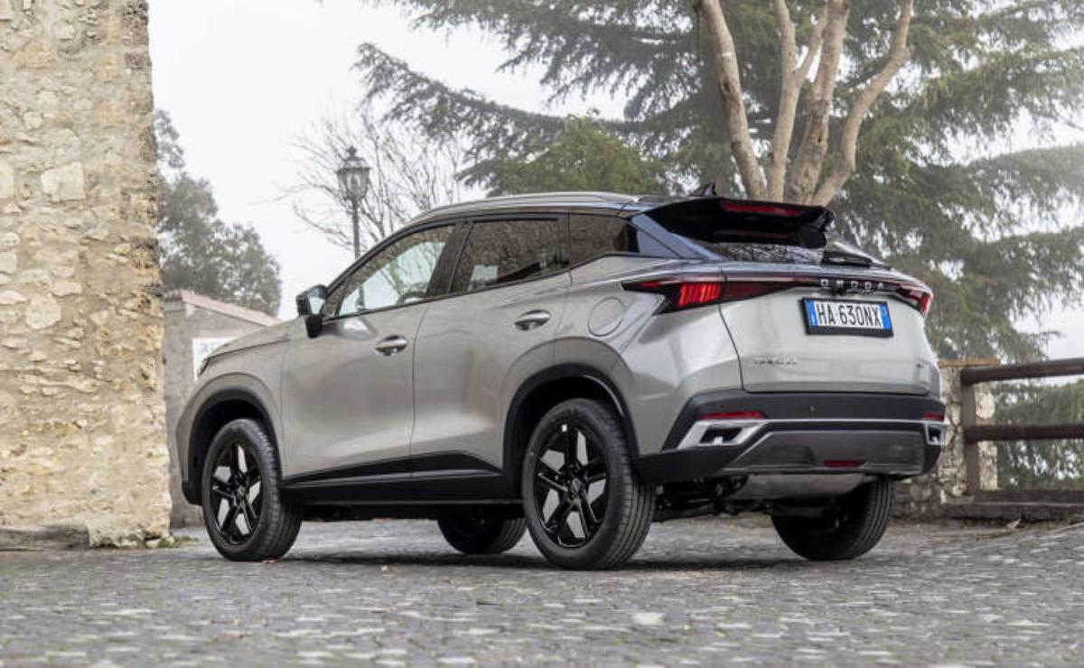 Silver SUV parked on a paved street under trees.