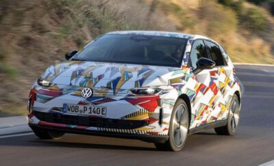 Volkswagen electric car with colorful geometric wrap driving on road.