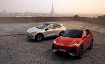 Two modern electric cars parked on a rooftop with a cityscape background.