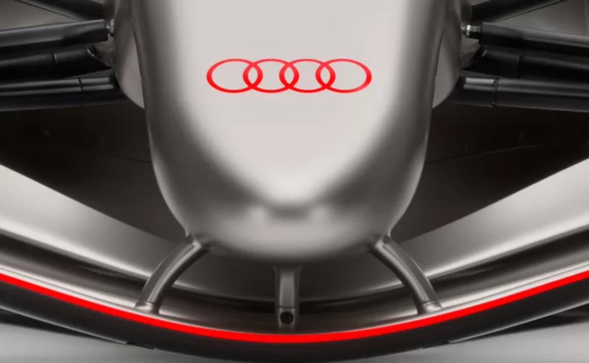 Close-up of Audi logo on a sleek silver car hood.