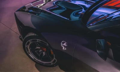 Close-up of a sleek black sports car with a distinctive logo on the side.