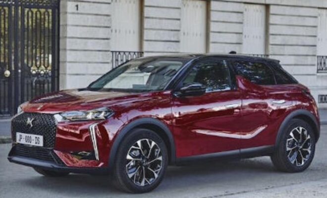 Sleek maroon SUV parked in front of a white building.