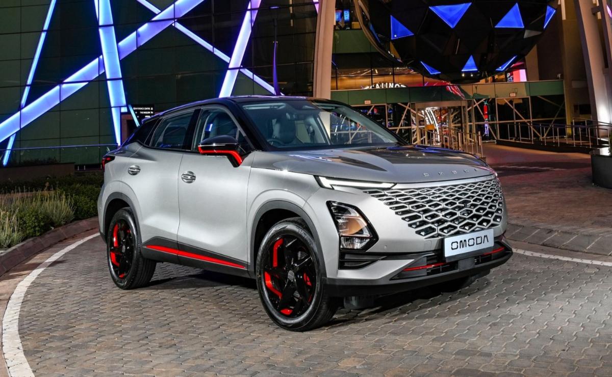 Sleek silver SUV with red accents parked at night under colorful lights.