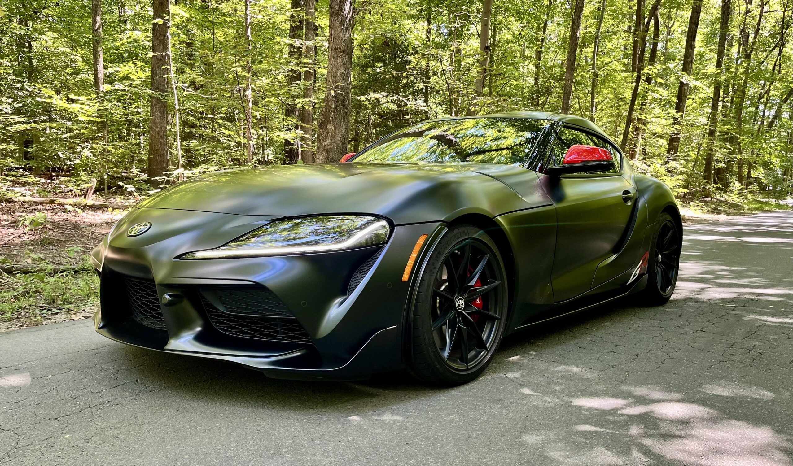 Dark gray 2026 Toyota GR Supra MkV Final Edition front three-quarter view with red mirror caps